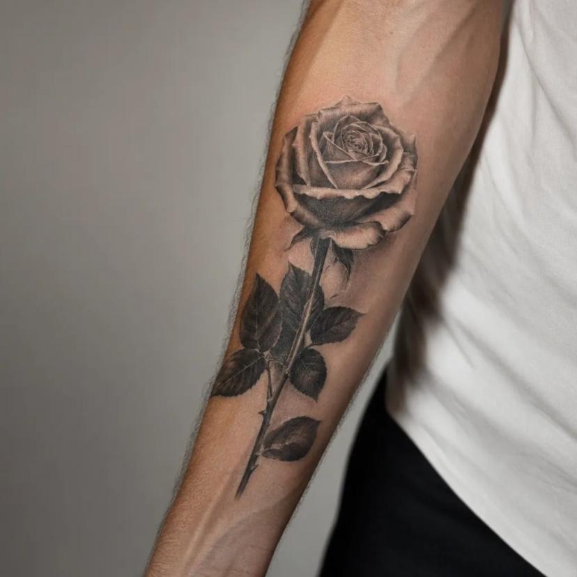 Tatouage rose réaliste à l'avant-bras, zone peu douloureuse, échelle 3 sur 10